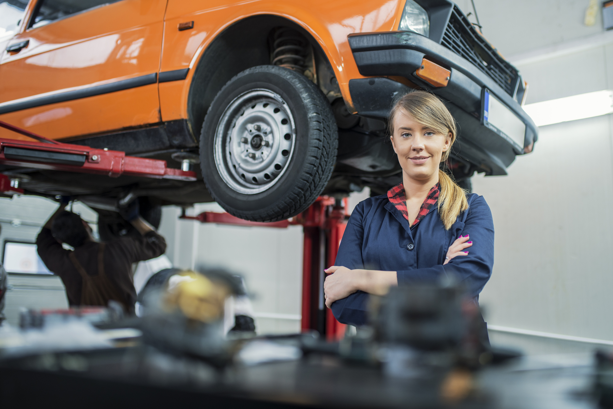 Female mechanic posing with vehicle