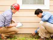 Home Inspectors looking at house foundation